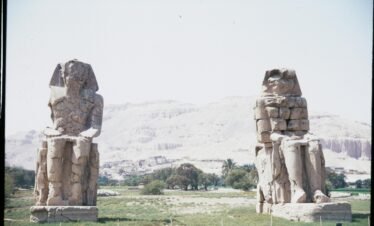 View of the Colossi of Memnon statues in Luxor, Egypt highlighting ancient Egyptian architecture.